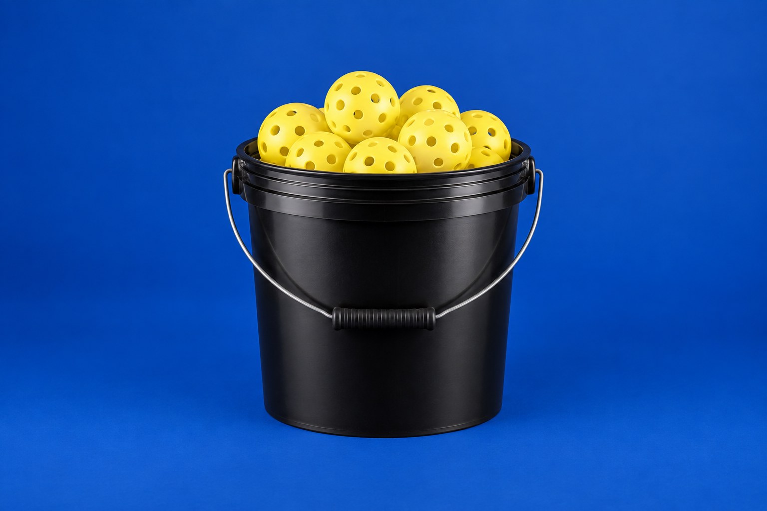 Bucket filled with yellow pickleballs